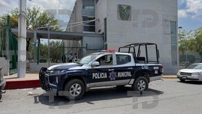 Se observa una fachada en color blanco con gris, hay una ambulancia estacionada.