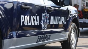 Patrulla de la Policía de Zapopan estacionada detrás de una ambulancia de la Cruz Verde con las puertas abiertas