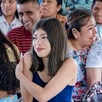 Mujeres y hombres escuchan una plática en un anexo.