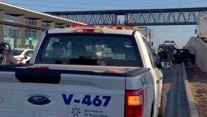 Patrulla de la Secretaría de Seguridad Pública de Jalisco estacionada al lado de una estación de Macro Periférico con agentes de la Policía Vial enfrente