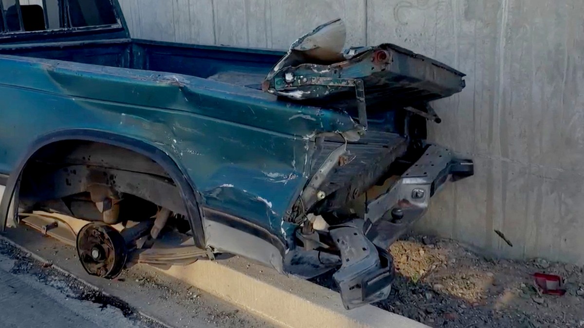 Camioneta color verde destruida de la parte trasera y sin una llanta estrellada contra un muro de contención en Carretera a Chapala