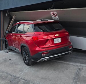 Se observa una camioneta color rojo que chocó contra la fachada de una vivienda.