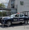 Se observa una fachada en color blanco con gris, hay una ambulancia estacionada.