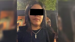 Mujer identificada como Wendy Fabiola, alias 'La Tía', con los ojos censurados por un recuadro negro siendo detenida al lado de una camioneta negra