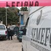 Cinta de seguridad roja junto a un vehículo del Semefo estacionado en Puebla.