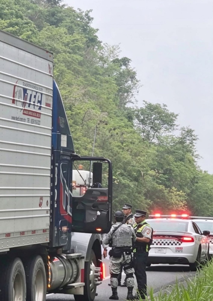 Policías abriendo la puerta del copiloto de un tráiler.