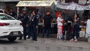Policías hablando con comerciantes en un puesto de comida.