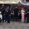 Policías hablando con comerciantes en un puesto de comida.