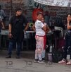 Policías hablando con comerciantes en un puesto de comida.