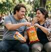 Una pareja de un hombre y una mujer con sobrepeso comiendo botana