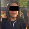 Mujer identificada como Wendy Fabiola, alias 'La Tía', con los ojos censurados por un recuadro negro siendo detenida al lado de una camioneta negra
