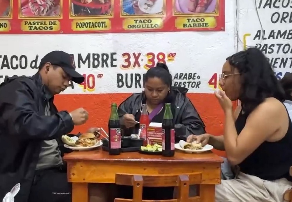 Familia comiendo tacos en un restaurante.