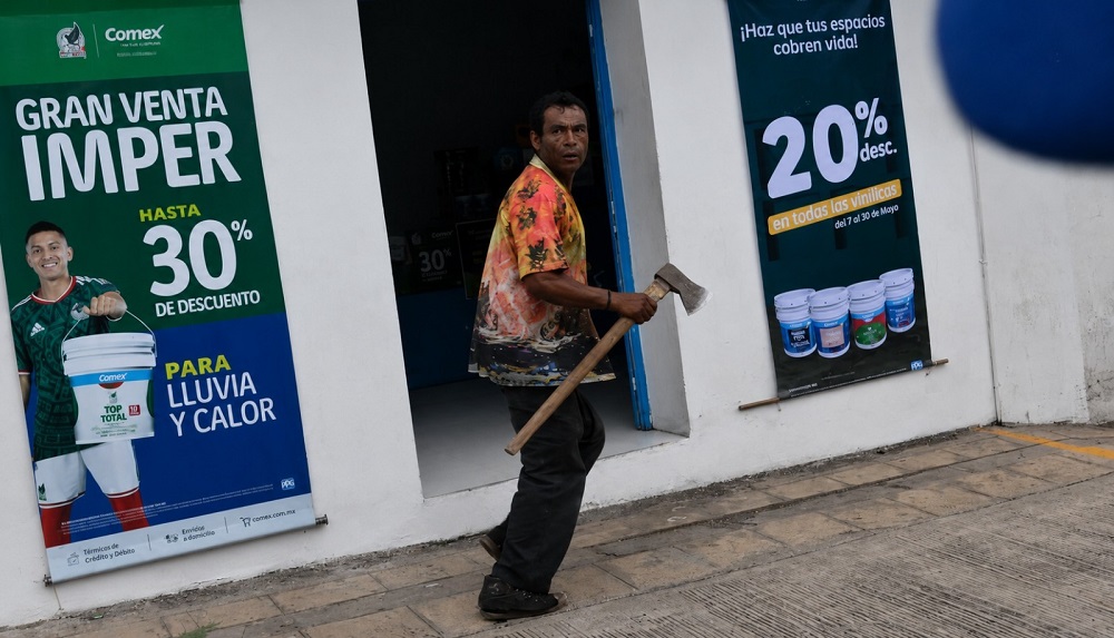 Hombre corriendo con un hacha sobre las manos.