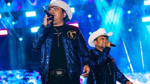 Agrupación con micrófonos arriba del escenario durante un concierto