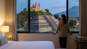 Persona dentro de una habitación de hotel con vista a  la pirámide de San Pedro Cholula