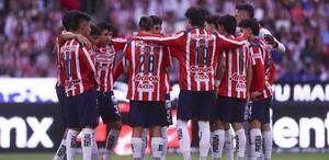 Los jugadores de Chivas reunidos en una parte del campo, mientras platican de lo que va a hacer ese partido