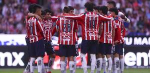Los jugadores de Chivas reunidos en una parte del campo, mientras platican de lo que va a hacer ese partido