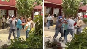 una mujer agrede a un hombre dentro de una escuela mientras otras personas intervienen para controlar la situación