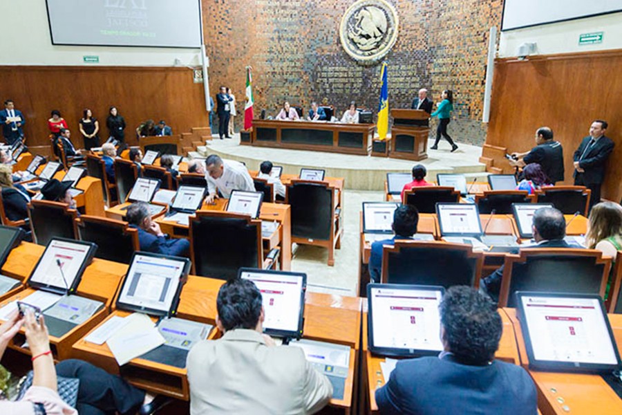 Diputados de Jalisco sentados delante de pantallas dentro del Congreso del Estado