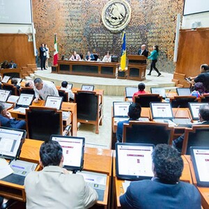 Diputados de Jalisco sentados delante de pantallas dentro del Congreso del Estado