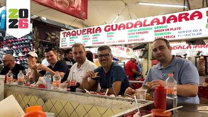 Grupo de varias personas sentadas en la barra de un puesto de tacos dentro de un mercado en Guadalajara