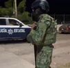 Militar de la Secretaría de Marina con una patrulla de la Policía del Estado de Colima pasando a un costado con policías a bordo