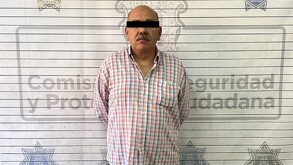 Se observa un hombre con ojos tapados con una cintilla negra.