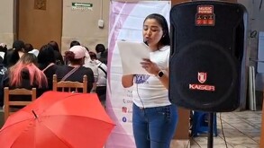 Mujer hablando ante un micrófono.