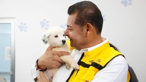 Armenta con un perro en los brazos