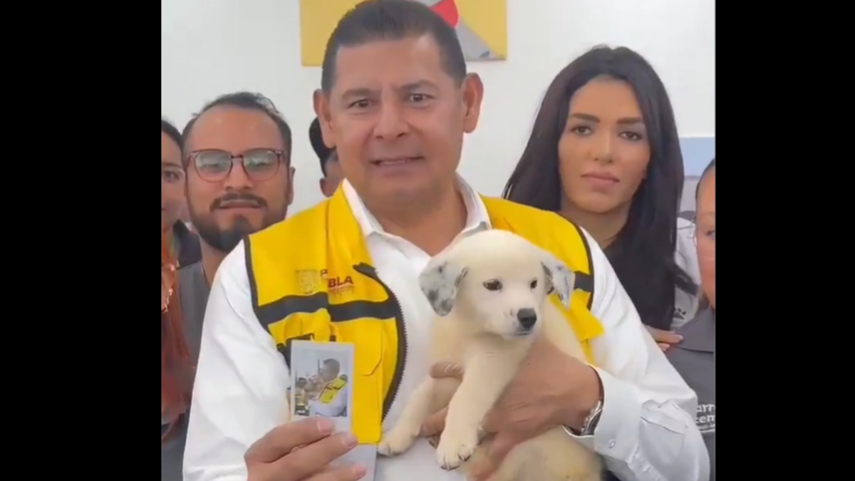 Armenta con un perro abrazando y mostrando la foto de su antiguo perro