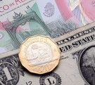 Dólares estadounidenses con billetes y moneda de 20 pesos mexicanos.
