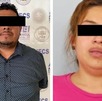 un hombre y una mujer detenidos con los ojos cubiertos