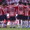 Los jugadores de Chivas reunidos en una parte del campo, mientras platican de lo que va a hacer ese partido