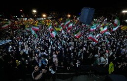 Manifestantes ondean banderas iraníes y del grupo político y militar libanés Hezbollah durante una reunión del progobierno en la plaza de la Revolución Islámica