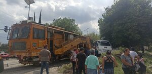 personas caminan a un costado de las vías del tren donde un microbús de la ruta 50 fue impactado