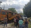 personas caminan a un costado de las vías del tren donde un microbús de la ruta 50 fue impactado