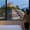 Persona dentro de una habitación de hotel con vista a  la pirámide de San Pedro Cholula