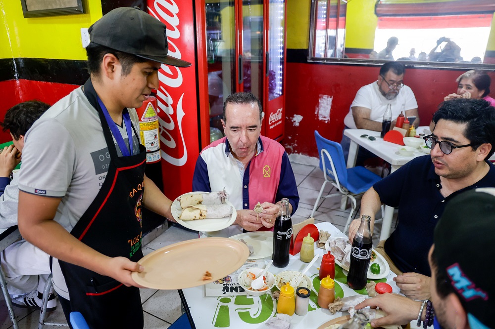 Mesero sirviendo tacos en Puebla.