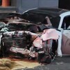 Automóvil color blanco con la puerta del conductor abierta y completamente destruido de la parte de enfrente tras un aparatoso choque