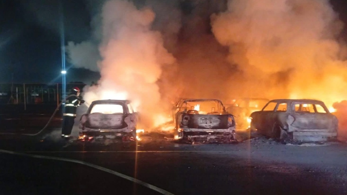 bomberos intentan sofocar un incendio que consume varios autos
