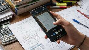 Un estudiante escaneando con su celular una hoja con gráficas