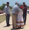Se observa a varios hombres rodeando a una niña vestida de blanco.