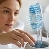 Mujer agarra un cepillo de dientes limpio de un vaso