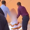 Se observa a dos hombres de pie y una niña que trae un vestido blanco.