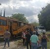 personas caminan a un costado de las vías del tren donde un microbús de la ruta 50 fue impactado