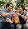 Una pareja de un hombre y una mujer con sobrepeso comiendo botana