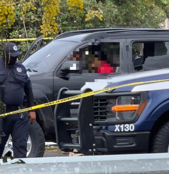 Hombre asesinado a balazos censurado dentro de una camioneta negra con los vidrios rotos con policía y una patrulla de Colima en un área acordonada