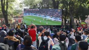 Pantalla gigante en el zócalo de Puebla con gente congregada para ver el partido