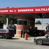 Se observa una fachada de un establecimiento en color gris con rojo y tiene letras que dice Estación de Bomberos.