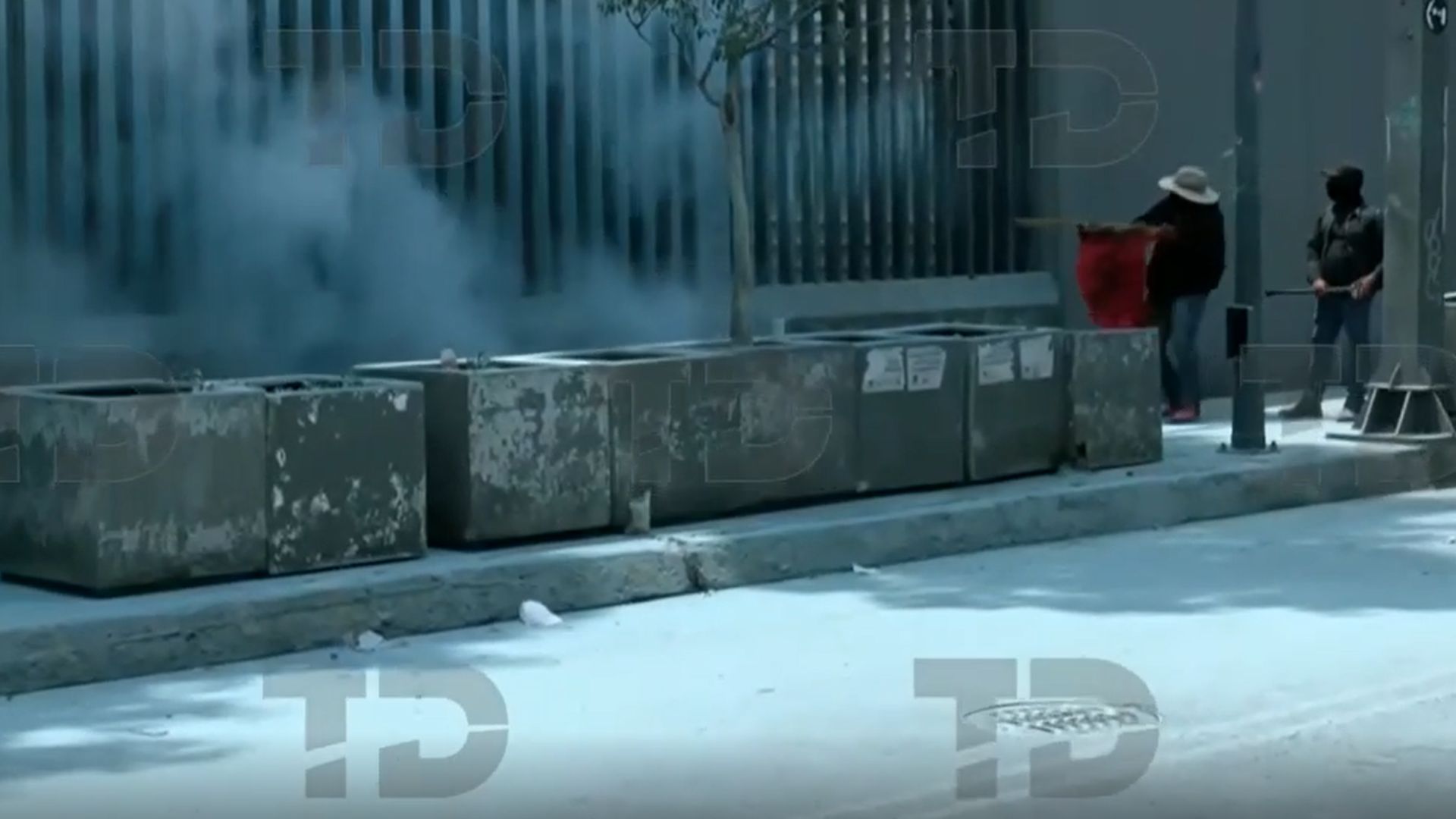 Manifestantes encapuchados de la CNTE vandalizan accesos de la SEP en la alcaldía Benito Juárez. Policías contienen los disturbios con extintores.